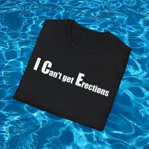 May include: Black crew neck t-shirt with the white text "I Can't get Erections". The shirt is displayed against a blue water background.