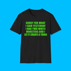 Peut inclure: Un t-shirt noir à manches courtes avec un texte vert vif qui dit : SORRY FOR WHAT I SAID YESTERDAY I HAD TWO WHITE MONSTERS AND I LET IT CREATE A THIRD. Le t-shirt présente une encolure ronde et une coupe standard, avec le texte centré sur la poitrine.