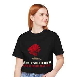 May include: Black t-shirt with a red flower graphic and the text "See how the world could be in spite of the way that it is."
