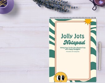 Op de afbeelding: Een notitieboekje met een groene en witte gestreepte omslag. De omslag heeft een gele ster en een glimlachend gezicht met grote ogen. De tekst op de omslag luidt "Jolly Jots Notepad" en "Giving Your To-Do List a Boost of Joy with Happy Squiggles! Includes 30 notepads."