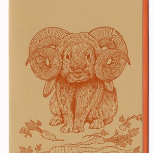 May include: A brown rabbit with large, curled horns and a serious expression. The rabbit is sitting on a brown background with green carrot tops and orange carrots.