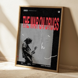 Könnte beinhalten: Ein schwarz-weißes Poster mit dem Text "THE WAR ON DRUGS" in Rot. Das Poster zeigt ein schwarz-weißes Bild einer Person, die Gitarre spielt. Der Text "Lost In The Dream" befindet sich am unteren Rand des Posters.