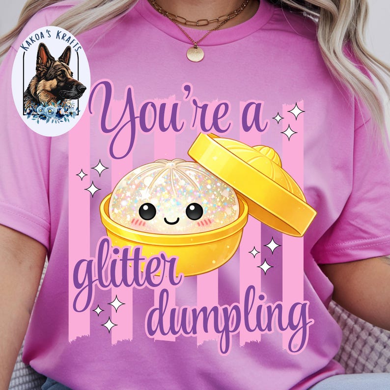 May include: Pink t-shirt with a graphic of a glittery dumpling in a yellow bowl. The text "You're a glitter dumpling" is written in a script font. The shirt also features a logo of a dog.