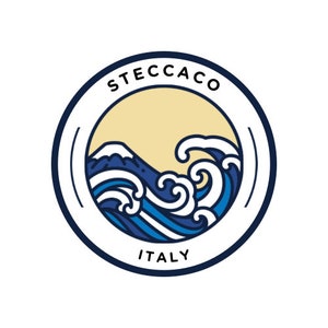 Può includere: Un design a onde blu e bianche con una montagna sullo sfondo. Il design è all'interno di un cerchio con il testo "STECCACO ITALY" attorno al bordo.