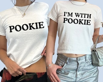 May include: Two white t-shirts with black text. One shirt says "POOKIE" and the other says "I'M WITH POOKIE".