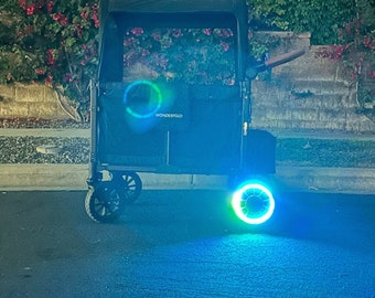 May include: A black wagon with a blue light on the wheel. The wagon has a black fabric top and the text "Wonderfold" printed on the side.