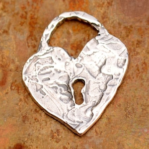 May include: A silver heart-shaped padlock pendant with a keyhole in the center. The pendant has a textured surface and a rustic look.