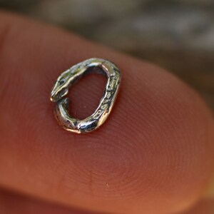 May include: A silver jump ring with a textured surface.