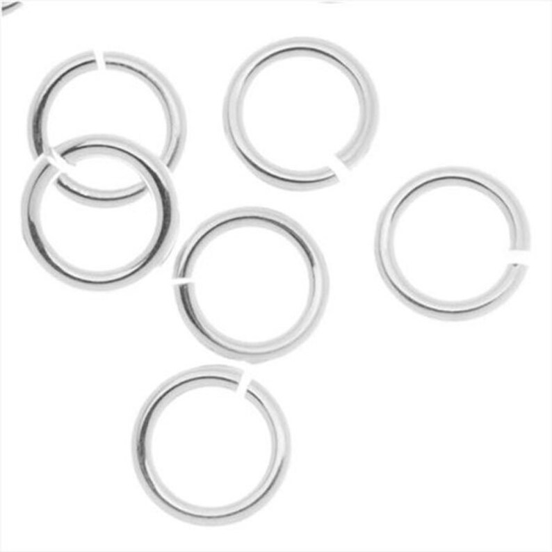 May include: Six silver jump rings, each with a circular shape and a gap for attaching jewelry components.