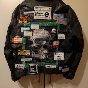 May include: A black leather jacket with various patches, including a skull, a Windows error message, and the text "Internet Explorer".