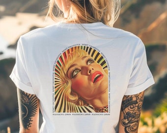 May include: A white t-shirt with a colorful graphic print of a woman's face with a sunburst design. The text "RADIANTLY LEMON RADIANTLY LEMON RADIANTLY LEMON" is printed around the graphic.