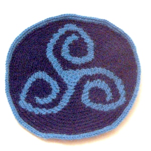 Peut inclure: Un symbole de triquetra crocheté en fil bleu et violet. Le triquetra est un symbole de nœud celtique qui représente la trinité.