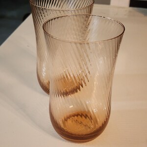 Puede incluir: Dos vasos de beber de vidrio transparente con un patr&oacute;n de espiral. Los vasos tienen un ligero tono &aacute;mbar.