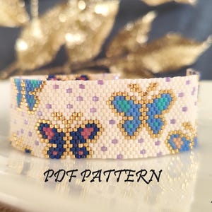 Pode incluir: Um bracelete branco de contas com um padrão de borboletas azuis e rosas. O bracelete está sobre uma superfície branca com o texto "PDF PATTERN" e "Borolina" visível.