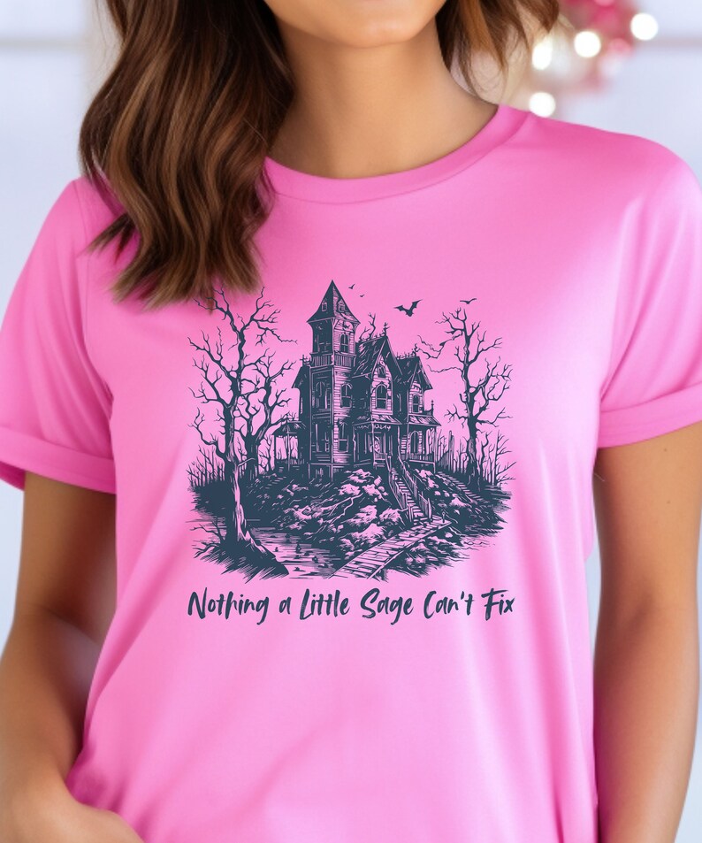 May include: Pink t-shirt with a black and white illustration of a haunted house and the text "Nothing a little Sage can't fix".