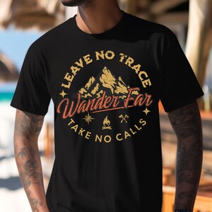 May include: A black short-sleeved t-shirt featuring a circular graphic with a mountain silhouette, a compass, a campfire, and crossed axes. The text reads "LEAVE NO TRACE", "Wander Far", and "TAKE NO CALLS" in a distressed yellow and orange font.