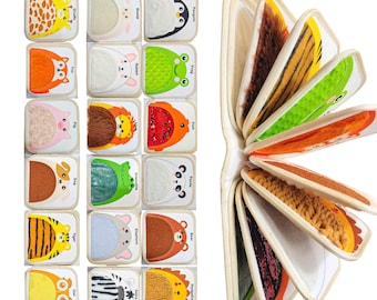 May include: A children's educational toy featuring a set of colorful animal-themed blocks and a book. The blocks display various animals like a giraffe, penguin, and frog. The book has textured pages with animal fur patterns. The overall design is bright and engaging.