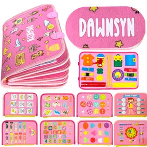 May include: Pink fabric activity book with multiple pages featuring various learning activities. Includes a cover with the name "DAWNSYN" and illustrations. Other pages have shapes, colors, and body parts. The book is designed for early childhood education.