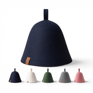 May include: A dark navy blue felt sauna hat with a conical shape, a top hanging loop, and a small brown leather tag featuring a steam icon. Below, five additional sauna hats are displayed in navy, white, forest green, gray, and dusty pink colors.