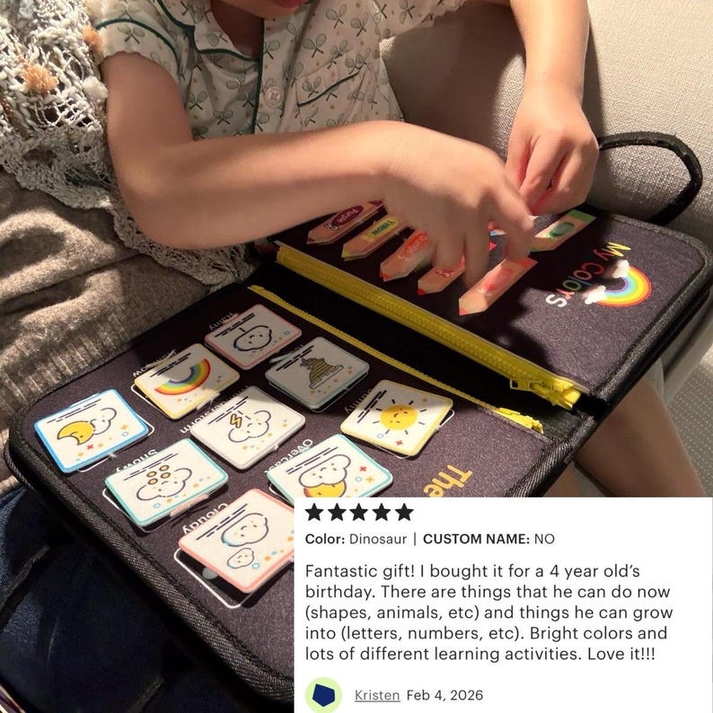 May include: A black educational activity book with a yellow zipper, featuring colorful illustrations and the text "My Colors." The book includes various learning activities with shapes, animals, and numbers. A rainbow and sun are also visible.