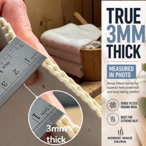 May include: A thick, off-white felted material being measured by a metal ruler showing a thickness of 3mm. The text on the right side reads TRUE 3MM THICK, MEASURED IN PHOTO, DENSE FELTED MERINO WOOL, BUILT FOR EXTREME HEAT, NORDIC WAVE SAUNA.