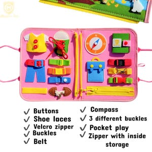 May include: A pink felt activity board featuring various tactile learning elements including a yellow vest with red buttons, a green shoe with red laces, a compass, a blue pocket, colorful straps with buckles, and a yellow zipper with storage.