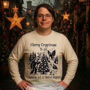 May include: Cream-colored sweatshirt with the text "Merry Cryptmas To All And to All A Weird Night." The graphic features a Christmas tree, Bigfoot, a bat, and other cryptids. The sweatshirt is long-sleeved.