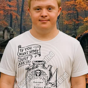 May include: A white t-shirt featuring a whimsical illustration with the text "IF YOU WANT SOME, JUST ASK US!". The design includes a potion bottle with a skull, a frog wearing a wizard hat, and the words "Potatoes and Molasses".