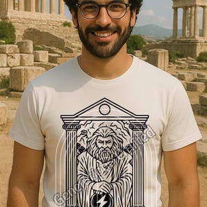 Könnte beinhalten: Weißes T-Shirt mit einer schwarzen Grafik von Zeus, dem griechischen Gott, in einem tempelartigen Rahmen. Das Design beinhaltet einen Blitz und den Namen "ZEUS" am unteren Rand. Der Hintergrund zeigt antike Ruinen.