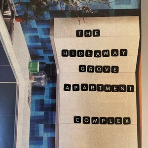May include: A rectangular print featuring a kitchen interior with blue tiled walls and a white countertop, overlaid with black letter tiles spelling out THE HIDEAWAY GROVE APARTMENT COMPLEX in a vertical arrangement on a light beige background.