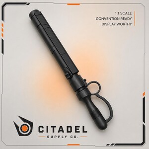 Può includere: Un manganello nero opaco con impugnatura a leva e un corpo cilindrico segmentato. Il testo 1:1 SCALE CONVENTION READY DISPLAY WORTHY è stampato nell'angolo in alto a destra, e il logo Citadel Supply Co. si trova nell'angolo in basso a sinistra.