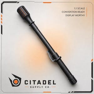 Puede incluir: Una porra negra con empuñadura texturizada, un clip central y una cabeza cilíndrica con detalles naranjas. El texto 1:1 SCALE CONVENTION READY DISPLAY WORTHY es visible, junto con el logotipo y el texto CITADEL SUPPLY CO. en la parte inferior.
