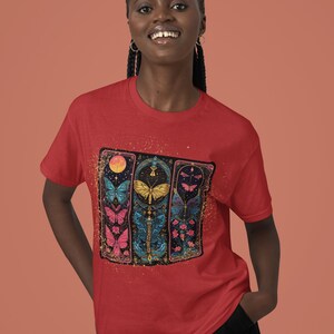 May include: Red t-shirt featuring a graphic of colourful butterflies in a stained glass style design.