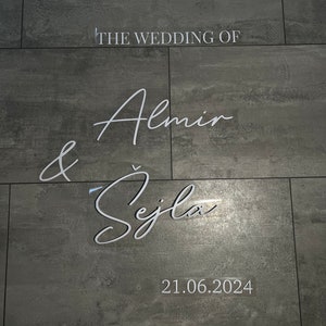May include: A wedding announcement on a grey tiled wall. The text reads "The Wedding of Almin & &Scaron;ejla 21.06.2024".