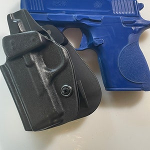 May include: A blue handgun with the text "CSX" and a black holster. The handgun is a Smith & Wesson model. The holster is made of a hard, molded material.