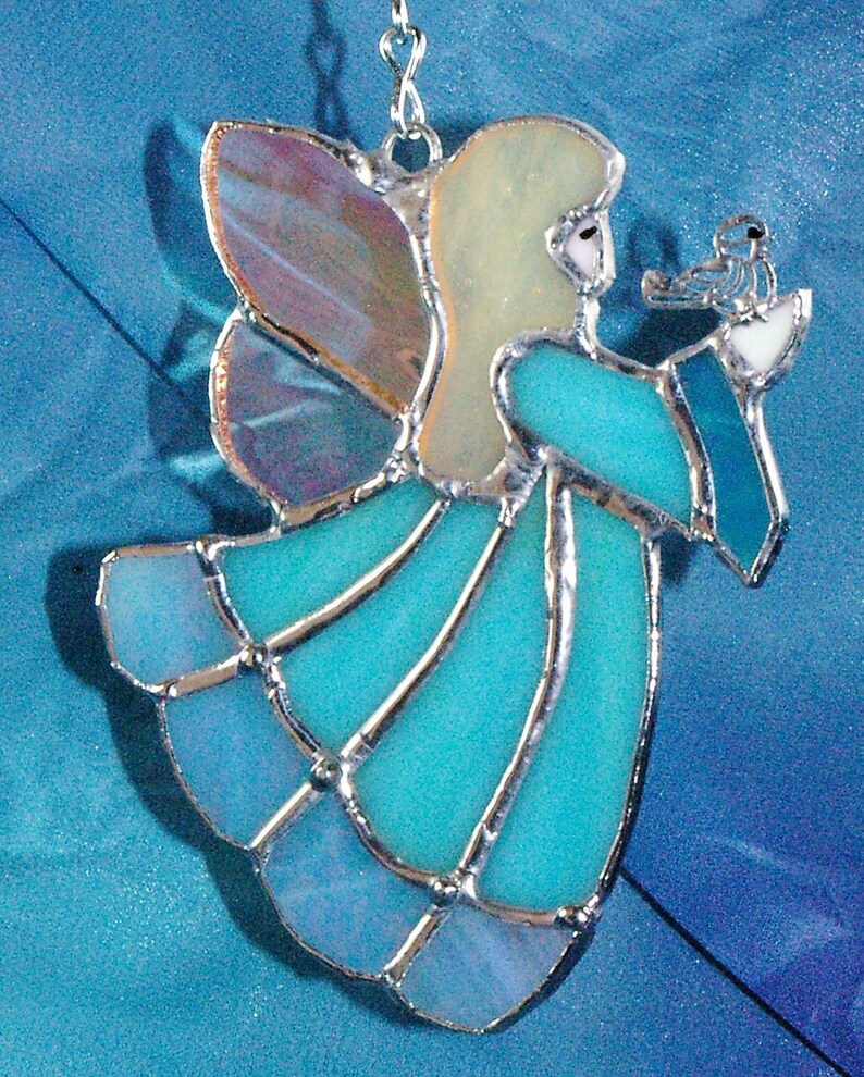 Handmade Blue Stained Glass Suncatcher Angel holding a bird on her hand.