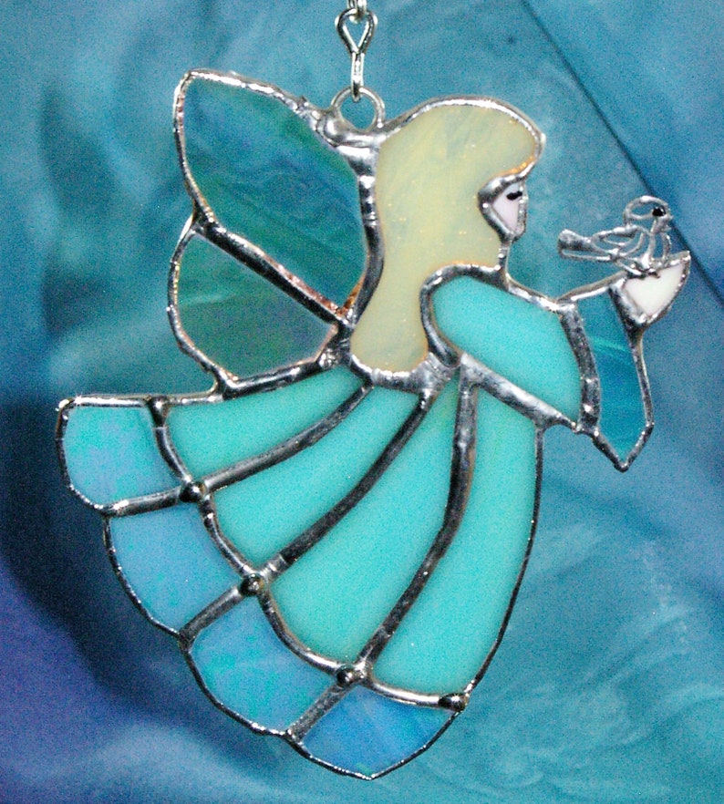 Handmade Blue Stained Glass Suncatcher Angel holding a bird on her hand.