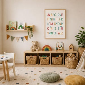 May include: A children's room featuring a wooden shelf with books, a framed alphabet poster, a low storage unit with four woven baskets, a teddy bear, a wooden rainbow, a bead maze, a teepee, a round table, chairs, and two floor cushions.