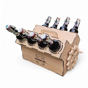 May include: Wooden beer bottle carrier shaped like an engine with the text "BIERMOTOR" on the front. The carrier holds six bottles and has a handle on the top.
