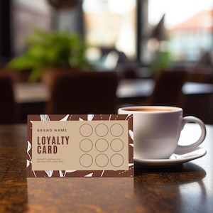 May include: A brown and tan loyalty card with nine circles for stamps, the words "LOYALTY CARD", and a white coffee cup on a saucer. The card has a decorative border and the text "Collect 9 stamps and get your 10th order free".