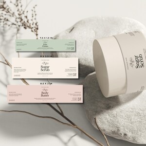 May include: A skincare product set featuring a round, off-white container labeled "Sugar Scrub" and three rectangular labels. The labels read "Face Cream", "Sugar Scrub", and "Body Butter". The labels are in pastel colors and are 19.05 x 3.81 cm, 20.32 x 6.35 cm, and 21.59 x 5.08 cm.