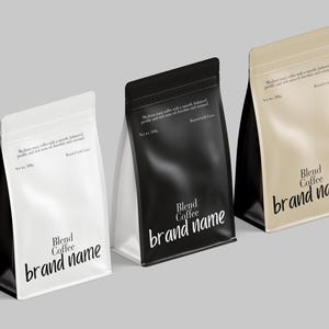 Op de afbeelding: Drie koffiezakken in wit, zwart en beige, elk met een glanzende afwerking. De zakken tonen de tekst "Blend Coffee brand name" in een modern lettertype. Elke zak heeft ook tekst die de koffiemelange beschrijft.