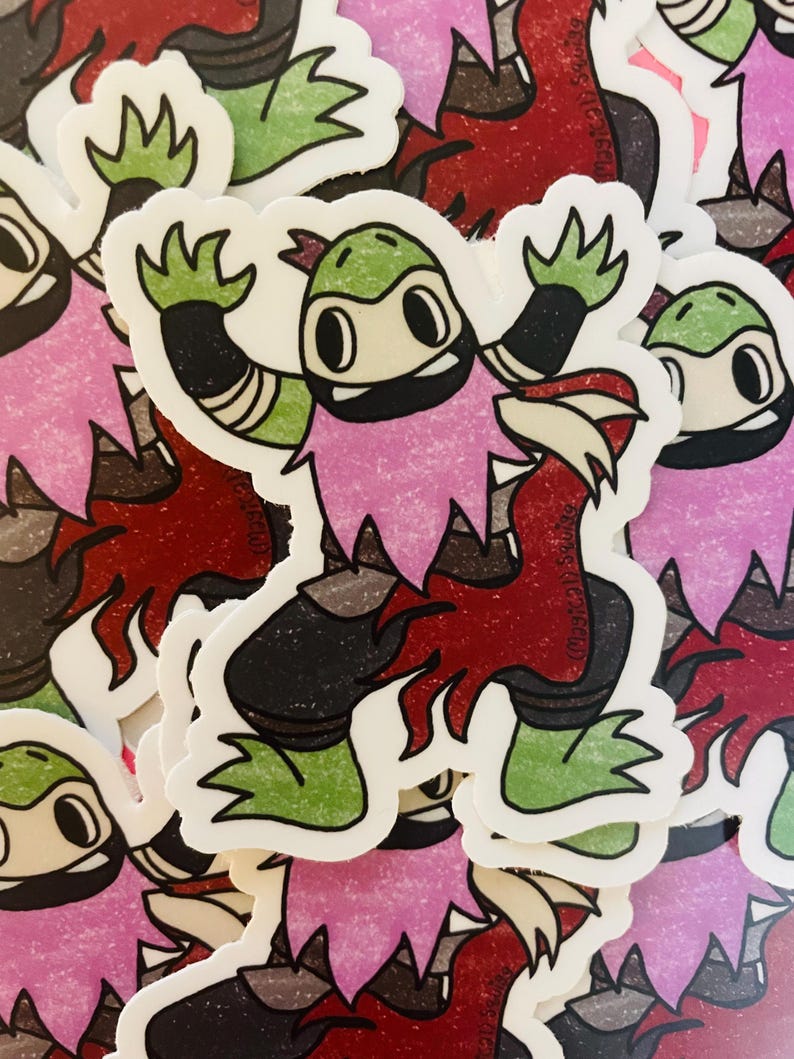May include: A sticker featuring a cartoon character with green skin, a pink mohawk, and a black mask. The character is wearing a black and white outfit and is in a fighting pose. The sticker is on a white background.