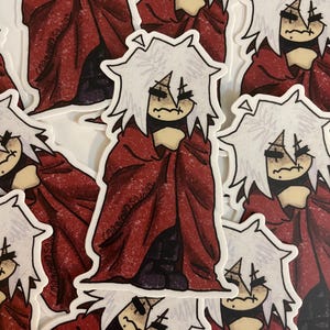 May include: A set of stickers featuring a white-haired character with a red cloak, drawn in a cartoon style. The character has a distressed expression and is holding the cloak around themself. The stickers are printed on white paper.