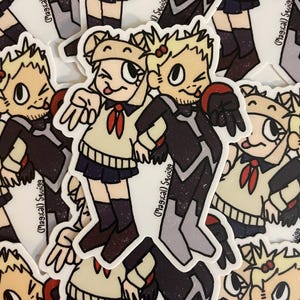May include: Two cartoon characters, a girl with blonde hair and a boy with black hair, are wearing school uniforms. The girl is wearing a white shirt with a red bow and a black skirt. The boy is wearing a black shirt with a white collar and a black skirt. The characters are standing side by side and smiling. The background is a white surface with a pattern of black and white dots.