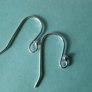 May include: Two silver earring hooks with a small ball at the end of each hook.