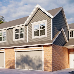 Peut inclure: Un bâtiment résidentiel à deux étages avec un toit et un bardage gris, comprenant plusieurs fenêtres et portes de garage. La façade combine briques et bardage, avec une garniture blanche. Le bâtiment est entouré d'arbres et d'un trottoir.