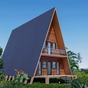 May include: A wooden A-frame house with a dark gray roof and large windows. The house has a deck with a railing and steps leading down to the ground. The house is surrounded by green grass and trees.