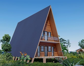 May include: A wooden A-frame house with a dark gray roof and large windows. The house has a deck with a railing and steps leading down to the ground. The house is surrounded by green grass and trees.