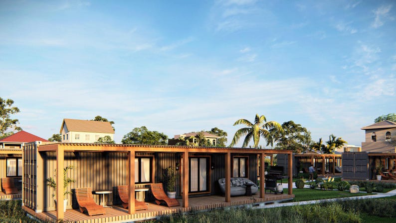 May include: A row of modern, wooden, prefabricated homes with a covered patio area. The homes have large windows and a light wood exterior.